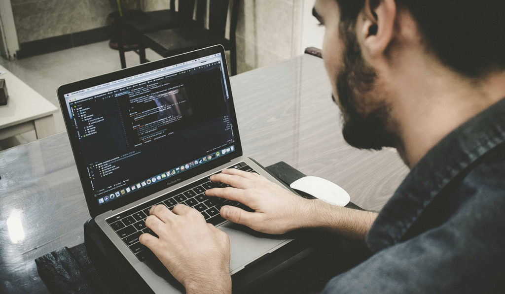 Man coding on a laptop
